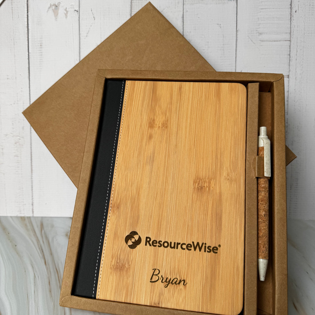Wooden notebook with black interior and pen in a box, featuring ResourceWise branding.