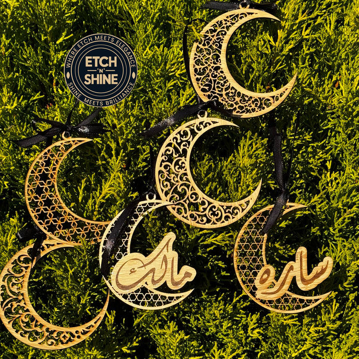 Decorative moon-shaped ornaments with intricate designs on a green leafy background, featuring the brand 'Etch & Shine'.