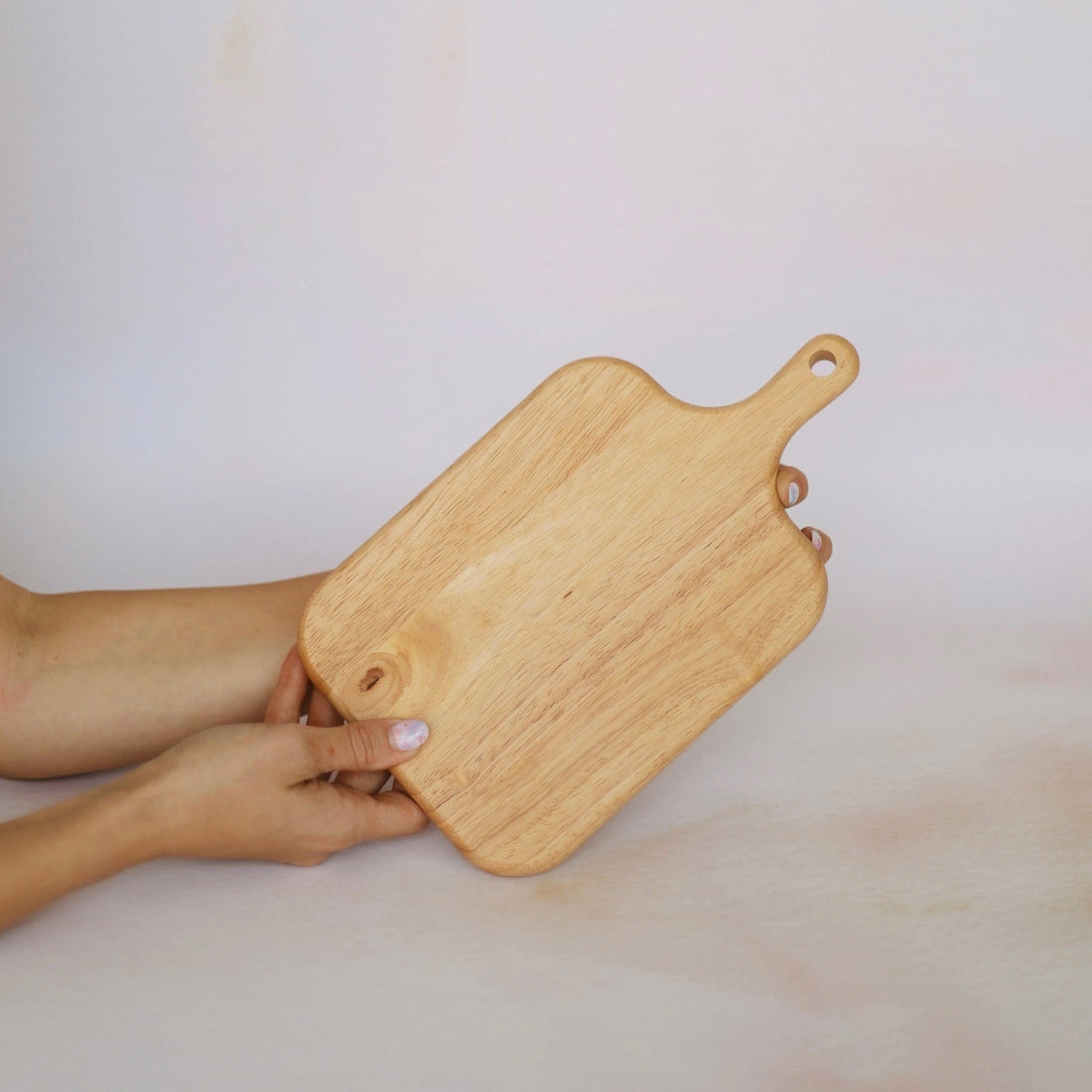 small oak board held in hand on a bright background