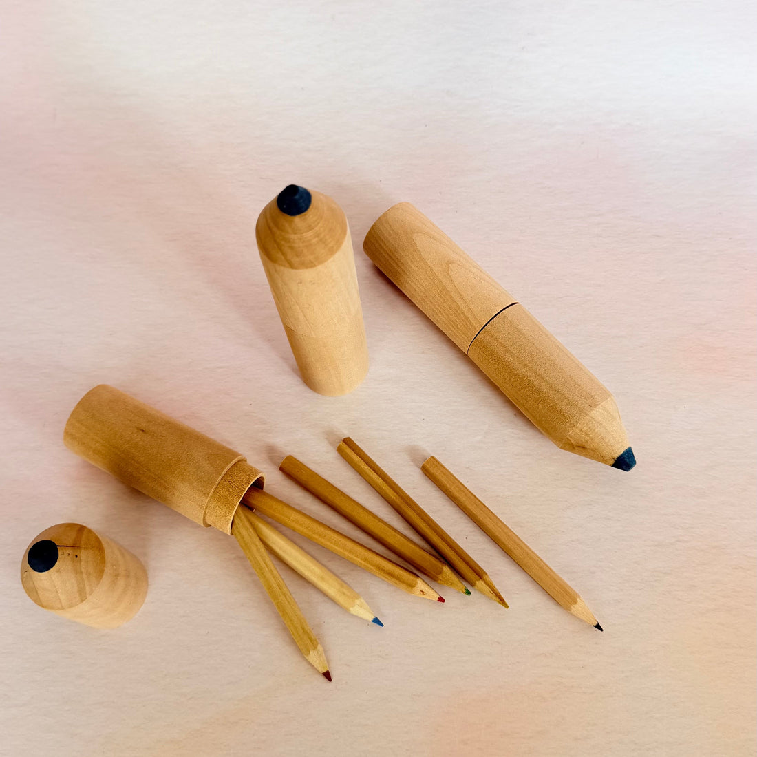 Set of wooden pencils on a light pink background