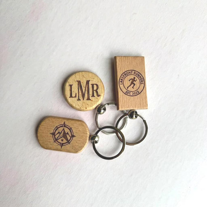 Engraved bamboo keyrings with custom names laid flat on a neutral surface – personalised wooden keyrings – Etch 'N' Shine
